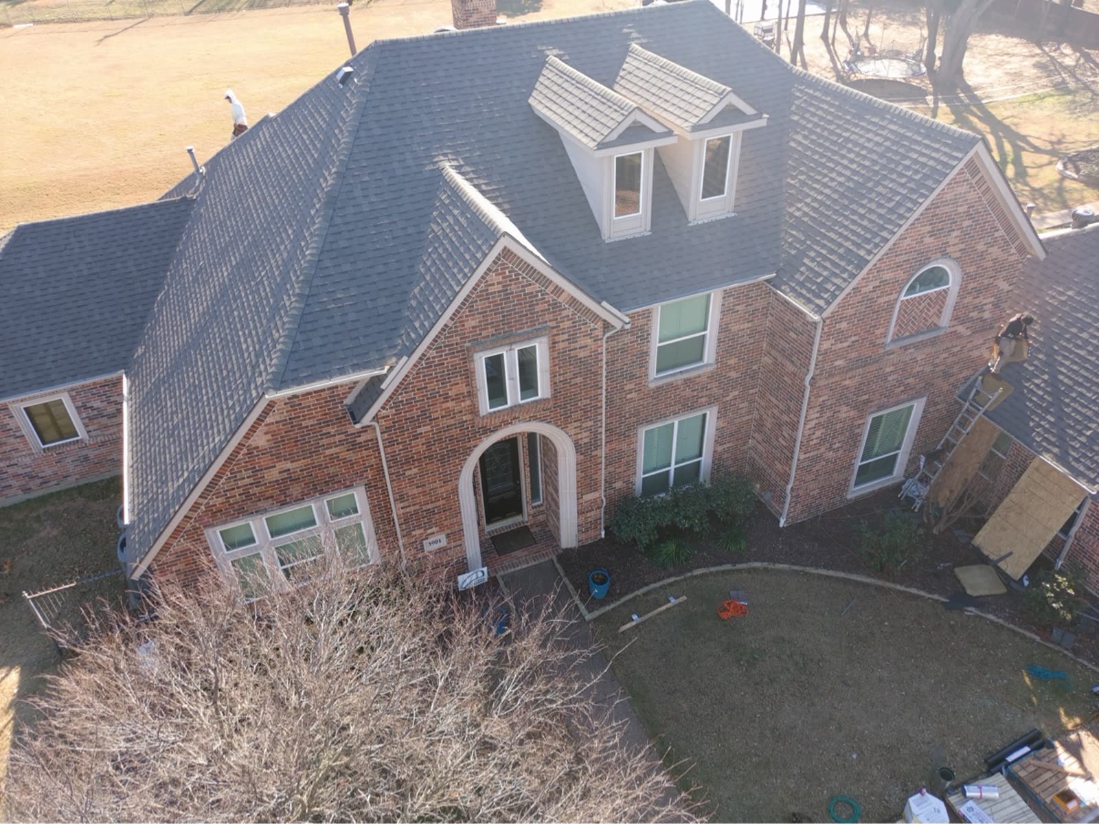 Finished dark shingle roof on a Flower Mound home — drone photo of the completed replacement